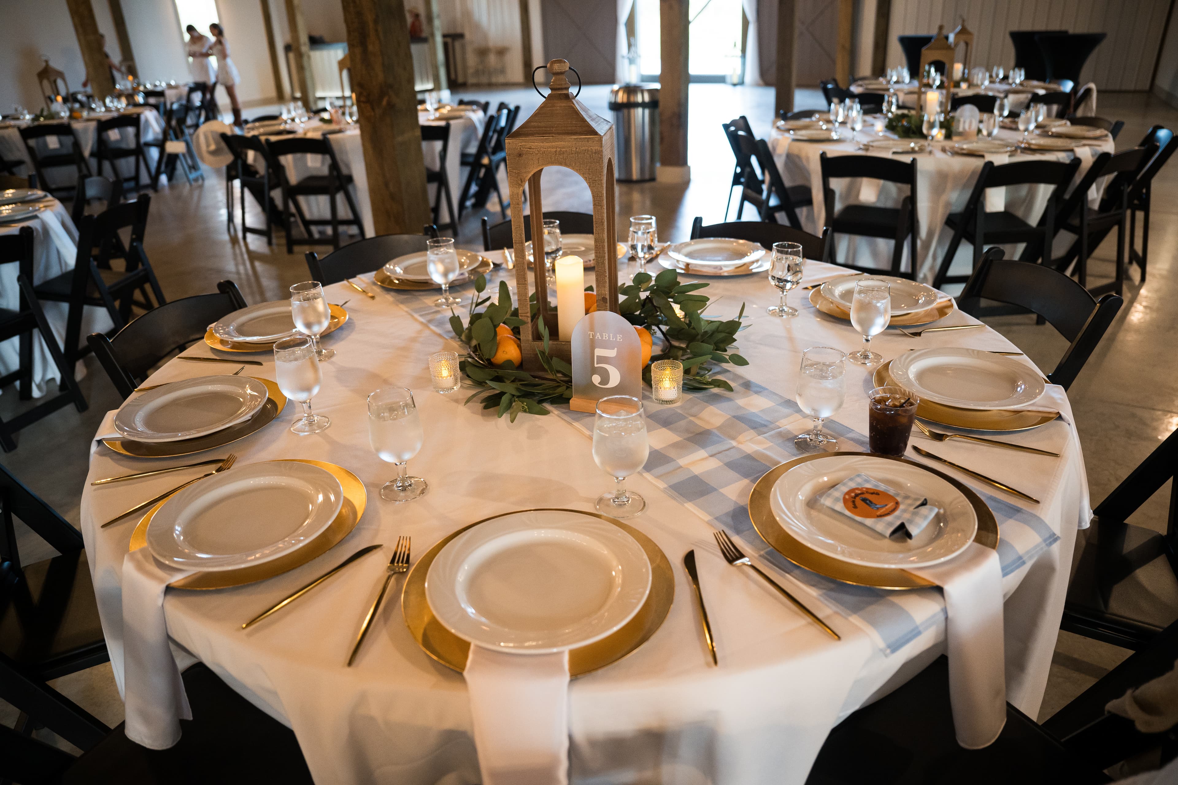 The reception hall set for dinner, barn doors open, daylight