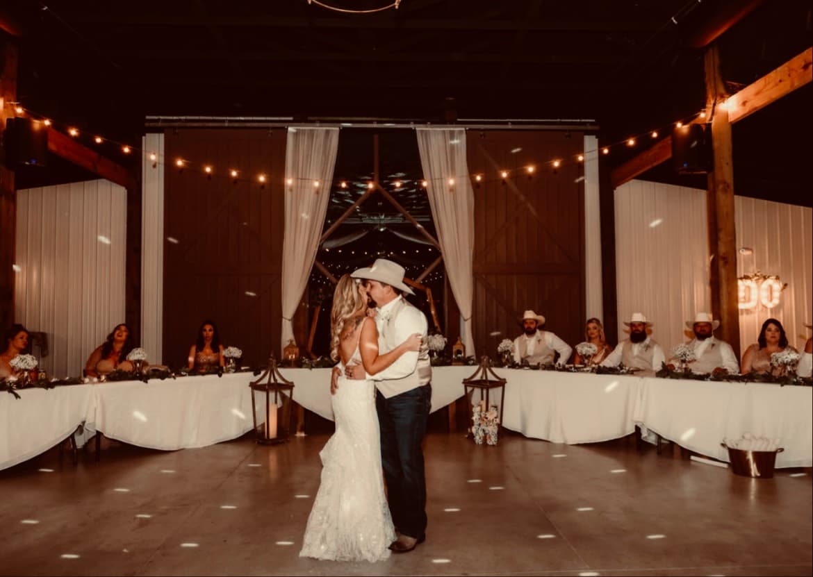 The first dance under string lights, the same barn doors, at night